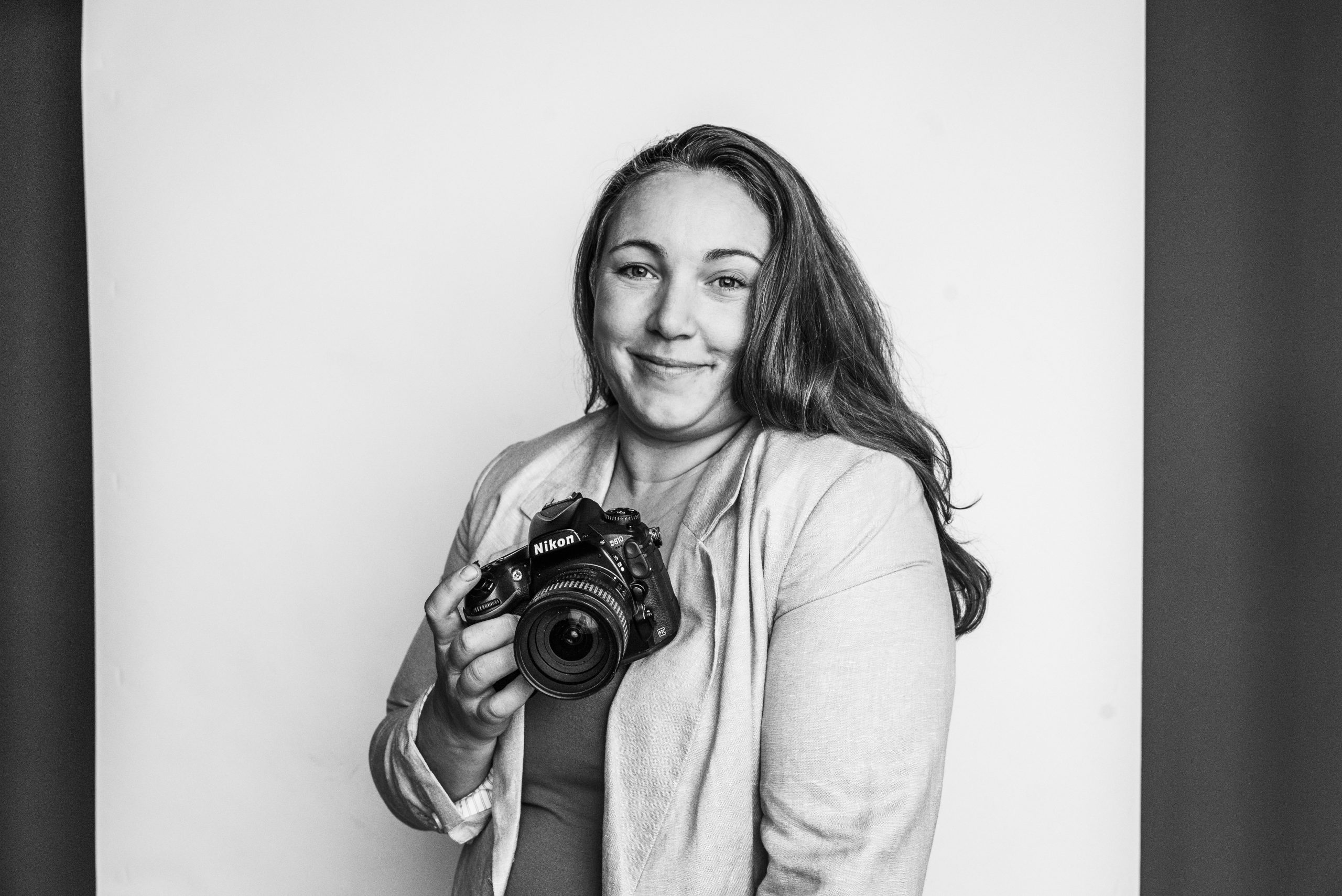 Black and white photo of a female holding a Nikon camera